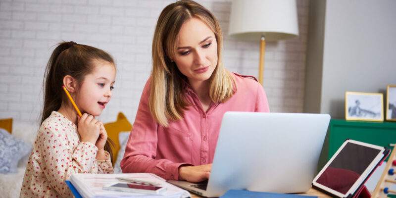 young-mother-working-from-home-with-a child girl